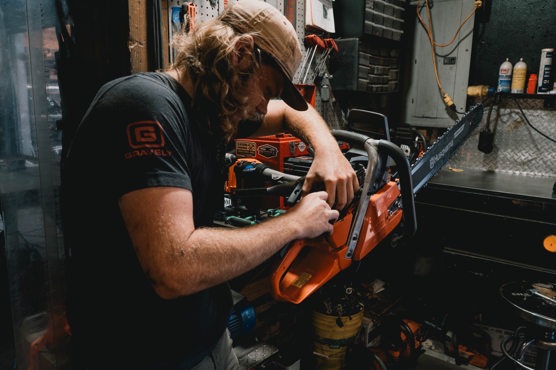 Technician servicing a Husqvarna chainsaw at the workbench
